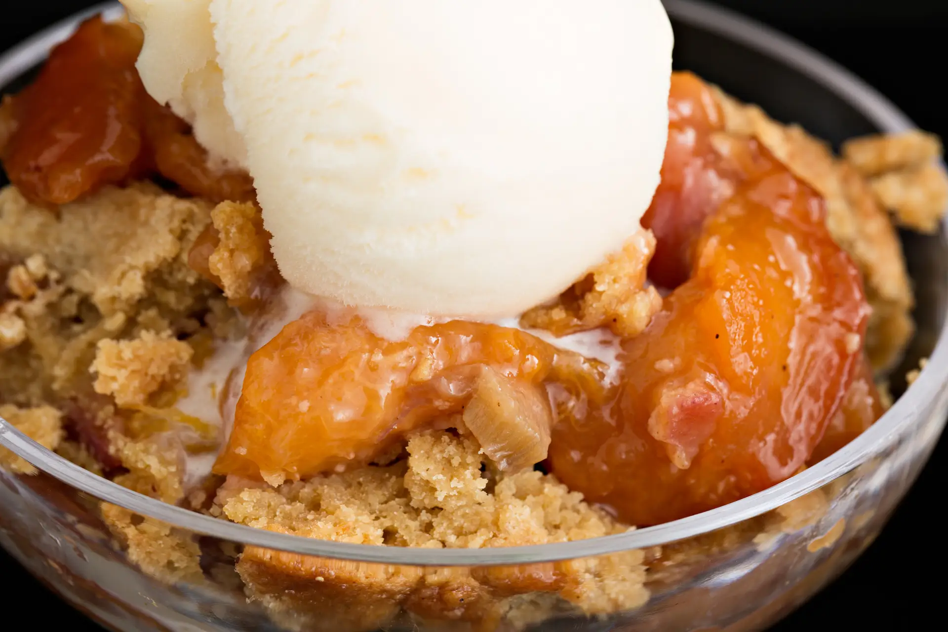 hot peach and rhubarb cobbler and a scoop of vanilla ice cream.